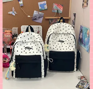 Detail view of trendy black and white star pattern school backpack on lifestyle desk setup.