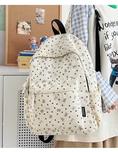 Corduroy backpack detail shot featuring cute heart and bow pattern with front pocket and straps.