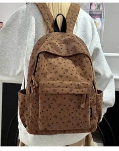 Detailed showcase of trendy brown corduroy backpack featuring cute heart and bow patterns for women.