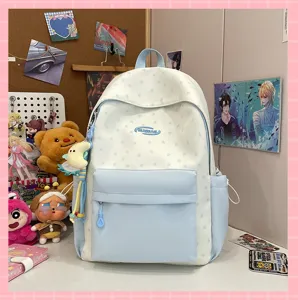 Cute star pattern school backpack in light blue and white, detailed view of front pocket and charm.