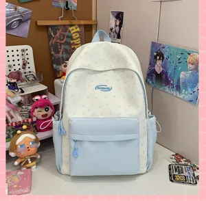 Detailed view of the light blue and white star pattern school backpack, front pocket display.