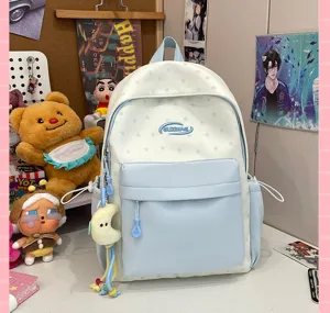 Detailed view of cute blue and white star pattern school backpack with plush moon pendant.