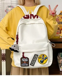 White casual backpack for students, large capacity book bag with trendy patches and charm.
