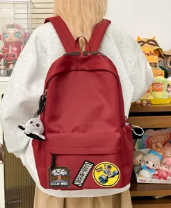 Large capacity casual canvas school backpack for students, stylish red daypack with fun patches.