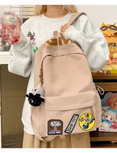 Casual canvas backpack detail shot featuring trendy patches and large capacity storage.