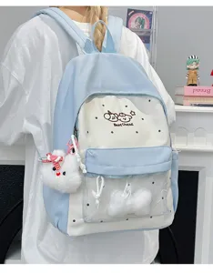 Detail view of clear front pocket school backpack with cute plush pendant and cartoon design.
