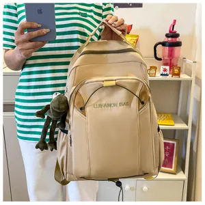 Casual beige canvas backpack with large capacity, multiple pockets and cute frog plush pendant.