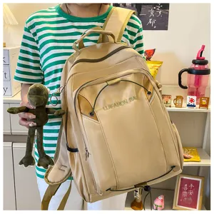 Large capacity casual khaki backpack with multiple pockets and cute frog plush pendant.