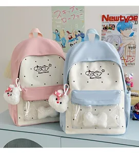 Cute pastel ita backpack detail showing transparent front pocket and fluffy heart pendant decor.