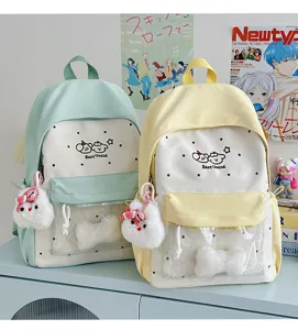 Cute student canvas backpack with transparent front pocket, polka dots, and adorable plush pendant.