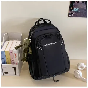 Detail view of black travel backpack with front pocket, waterproof fabric and cute frog plush.