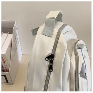 Detail view of a white casual backpack with durable zippers and straps for students.