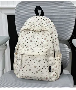 Corduroy backpack detail, cute heart and bow pattern, casual daily use design, front pocket.