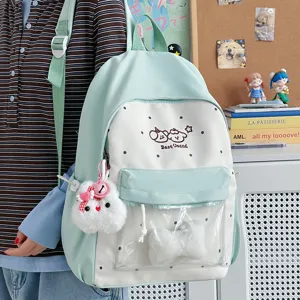 Cute mint green polka dot school backpack for teen girls with clear front pocket and plush bunny charm.