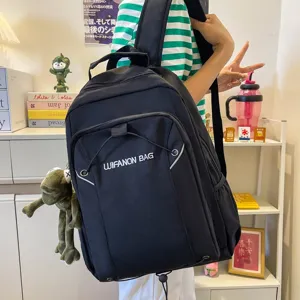 Stylish black backpack with cute plush pendant, large capacity for school and travel.