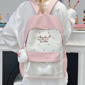 Pink and white polka dot backpack with clear front pocket and cute plush charm for daily use