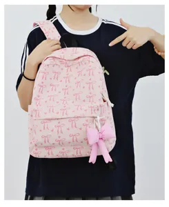 Close-up detail view of the sweet pink corduroy backpack showcasing charming bow pattern and charm.