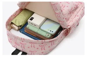 Pink corduroy bow backpack interior capacity detail view showcasing spacious storage compartments.