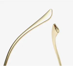 Gold metal eyeglass frame detail shot featuring fine craftsmanship and smooth curved temple design.