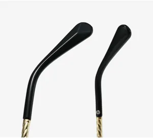 Close-up view of the glasses temple, featuring a stylish black tip and gold twisted metal arm.