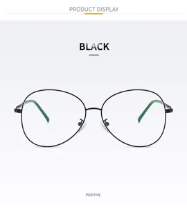 Detail view of oval metal eyeglasses frame in black with green temple tips for clear lenses.