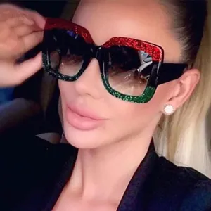 Lunettes de soleil carrees surdimensionnees avec montures pailletees rouges et vertes.