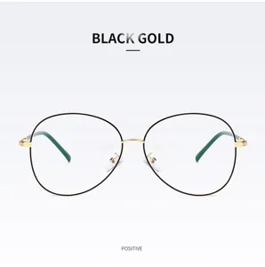 Close-up detail of black and gold oval metal eyeglass frame with green temple tips.