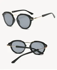 Detailed view of trendy round frame sunglasses with black and gold design and grey lenses.