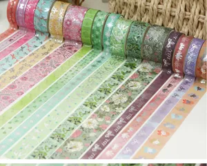 Gros plan de rouleaux de ruban adhésif Washi à motifs floraux et de rubans, papeterie déco.
