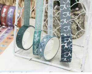 Détail de ruban adhésif washi décoratif, rouleaux verts et bleus avec finition métallisée.