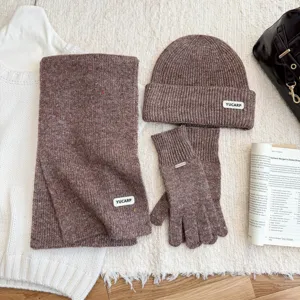 Détail de l'ensemble écharpe bonnet gants en tricot chiné marron avec texture douce.
