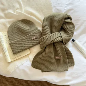 Detailed view of cozy winter knitted hat and scarf set in solid green, warm and stylishly textured.