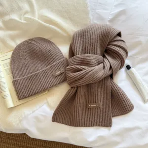 Detailed shot of cozy brown knit beanie and scarf set showcasing soft texture and warm fabric.