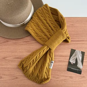 Mustard yellow knitted cross scarf for women, warm winter neck warmer with cable knit texture.