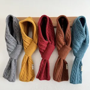 Detailed view of cozy chunky cable knit winter cross scarves in vibrant solid colors hanging.