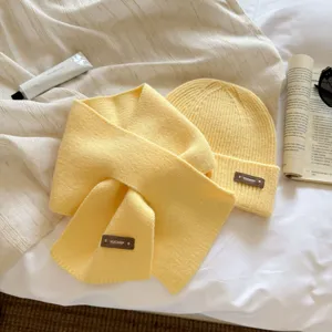 Detailed close-up view of the cozy yellow knitted scarf and beanie set with soft fabric texture.
