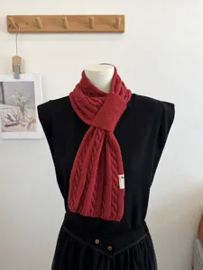 Red cable knit scarf detail, winter warm neck wrap, soft woolen fashion accessory.