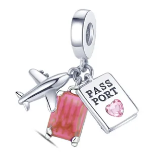 Silver travel dangle charm close-up, featuring airplane, pink suitcase and passport bead.