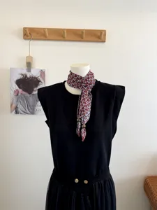 Gedetailleerd overzicht van een vintage bedrukte halsdoek met houten kraalsluiting, elegant.