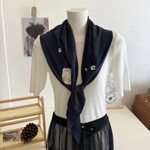 Vue détaillée du foulard triangulaire tricoté élégant avec broderie florale délicate.