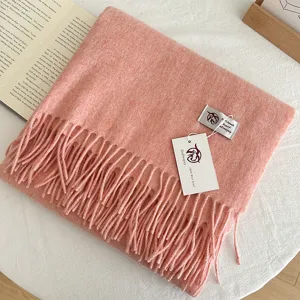 Cozy pink wool scarf for women with elegant fringe design, soft and warm winter accessory.