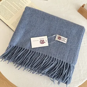 Cozy light blue 100% wool scarf featuring elegant fringe details and soft texture for winter.