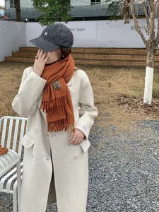 Chic winter solid color wool blend coat paired with cozy knit scarf and casual hat.