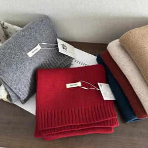 Detailed view of cozy 100% wool knitted winter scarves in multiple colors neatly folded.