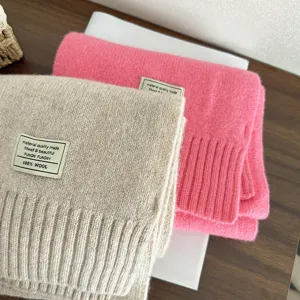 Cozy 100% wool knitted winter scarf in stylish pink and beige colors, soft warm winter accessory.