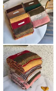 Detail shot of color-blocked knitted scarf showing soft texture and striped patterns.