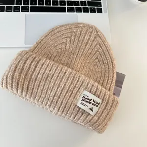 Close-up view of a thick wool-blend knit beanie with a stylish patch detail for winter.