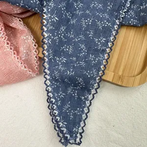 Detailed closeup shot of cotton linen floral lace triangular scarf with crochet trim.