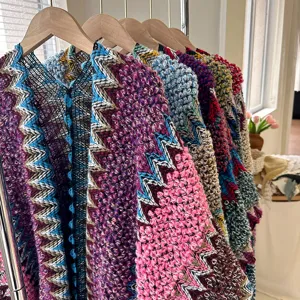 Colorful knitted tribal poncho cape detail showing textured zig-zag pattern and vibrant yarns.