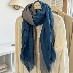 Detailansicht des blau-grauen Leinen-Knittertuchs, drapiert an einem hellen Blusenbügel.